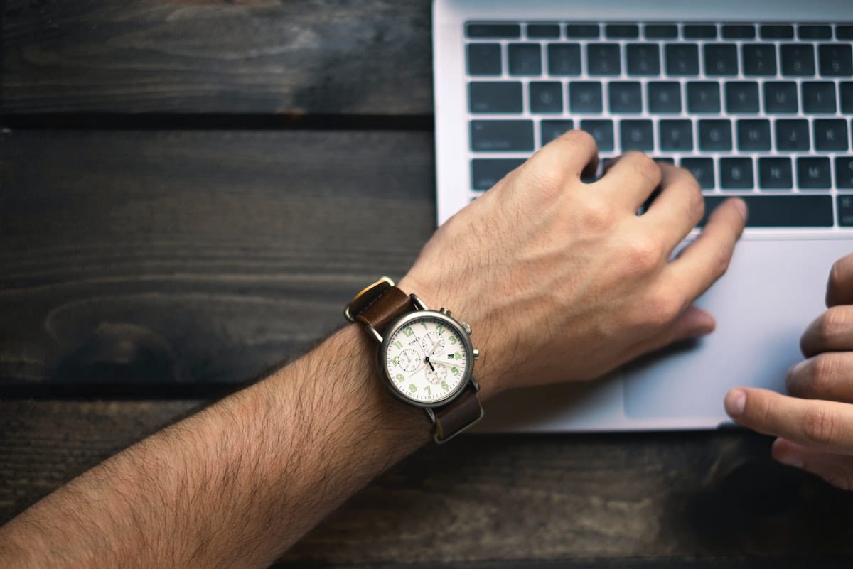 Man with a watch typing